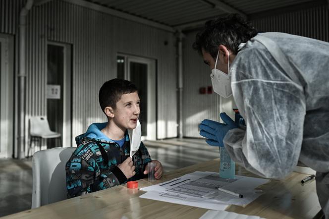 Un écolier écoute les instructions pendant un test salivaire de COVID-19, dans une école primaire d’Eysines, près de Bordeaux, le 25 février 2021.