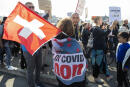FILE - Protesters gather for a demonstration march against civil restrictions and the COVID-19 vaccine, in Geneva, Switzerland, Oct. 9, 2021. Switzerland is facing an exponential rise in coronavirus cases. But its federal government, hasn't responded with new lockdown measures. Experts say that's because the government's anti-COVID policies face a crucial test at the ballot box. On Sunday Nov. 28, 2021, Swiss voters will cast ballots on a ‚COVID-19 law' that has unlocked billions of Swiss francs in aid for workers and businesses hit by the pandemic. (Salvatore Di Nolfi/Keystone via AP, File)