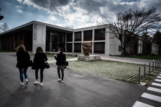 Des étudiants passent devant la statue « Hypnos » de l’artiste espagnol José Seguiri, à l’entrée du campus de Sciences Po Grenoble, à Saint-Martin-d’Hères, le 8 mars 2021.