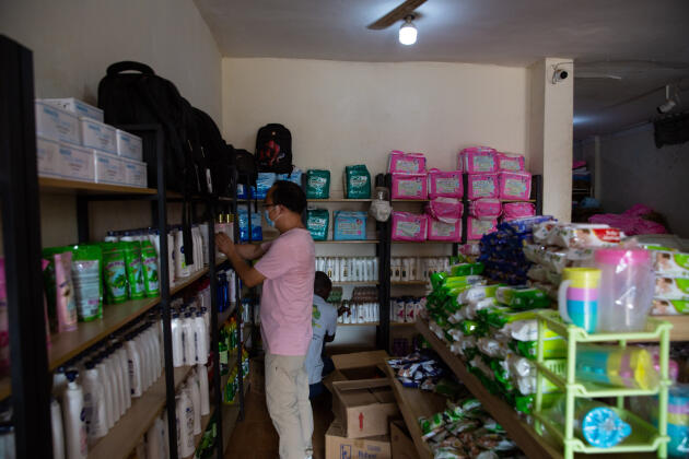 Mr Sundafu, a Chinese businessman, arranges the items in his wholesale store where he sells women's body creams and baby clothes, in Juba, South Sudan on November 20, 2021