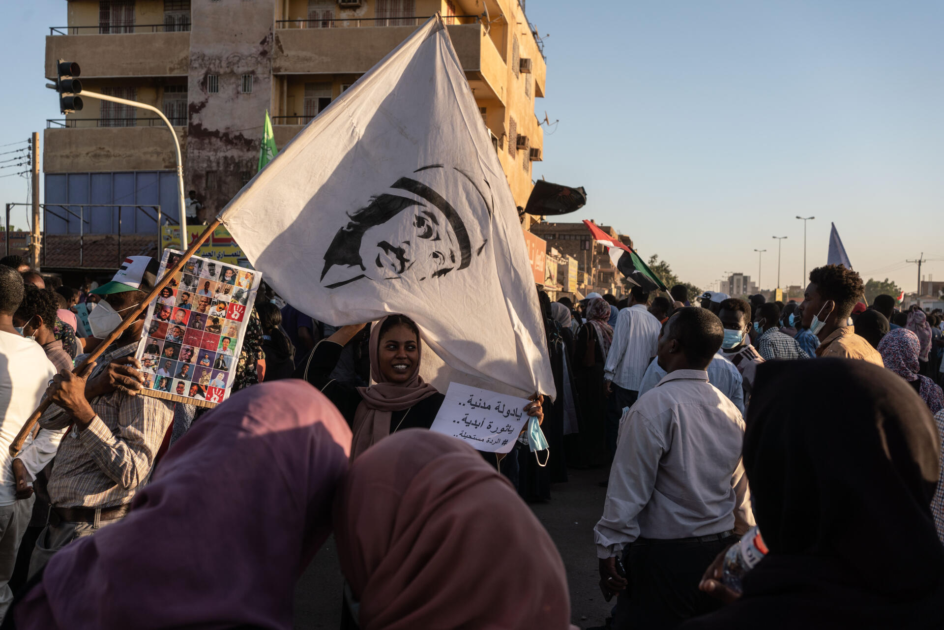 Une manifestante tient une pancarte sur laquelle est écrit « Soit un Etat civil... soit révolution éternelle », pendant une marche dans le quartier d'Al-Sahafa, à Khartoum, le 25 novembre 2021.