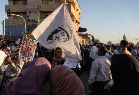 une manifestant tient une pancarte sur laquelle est écrit "Soit un état civil... soit révolution éternelle" pendant une manifestation dans le quartier d'Al-Sahafa à Khartoum le le 25 novembre 2021.