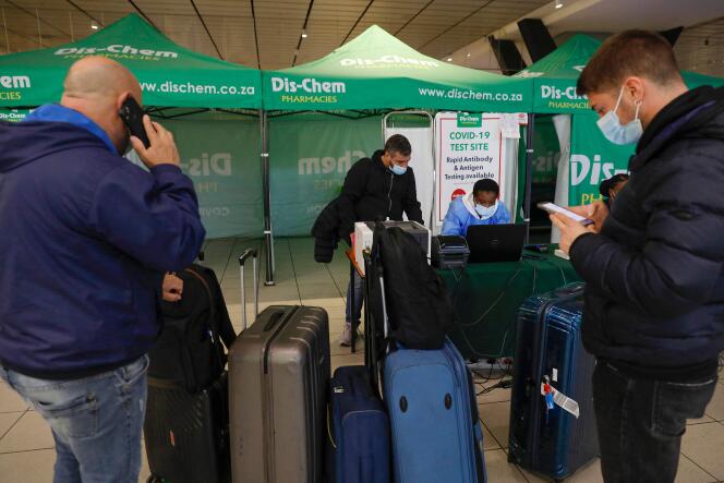 Des voyageurs attendent pour réaliser un test PCR, à l’aéroport international de Johannesburg, en Afrique du Sud, le 27 novembre 2021.