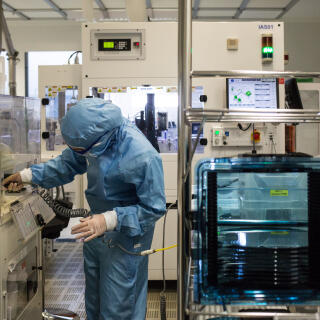 Une employée dans une des salles blanches de Soitec à Bernin (Isère) qui produit des plaques de silicium le 26-11-21.