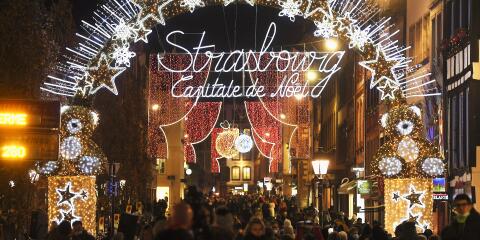 This picture taken on November 26, 2021 shows a view of the city's illuminated sign and Christmas street decorations as people gather on the opening day of the the traditional Christmas market in Strasbourg, eastern France. (Photo by Frederick FLORIN / AFP)