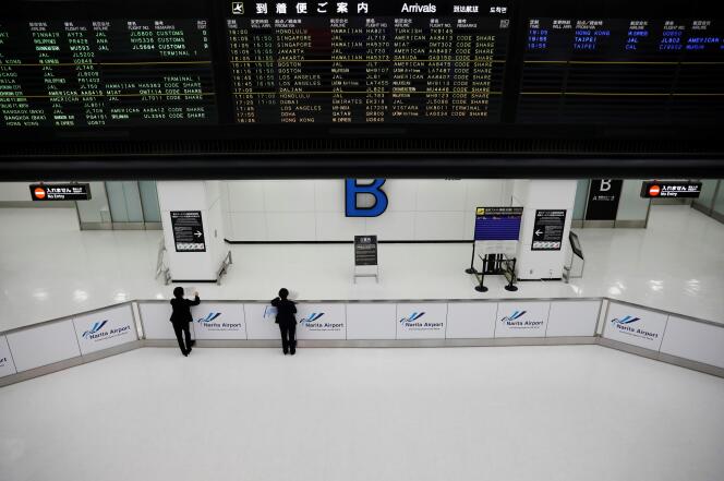 Le personnel de l’aéroport de Narita, à Tokyo, attend les passagers dans le hall d’arrivée au premier jour de la fermeture des frontières de l’Archipel, le 30 novembre 2021.