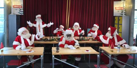 Santas sit in class as they take part in Santa School at The Ministry of Fun in London on November 30, 2021, a series of training courses for professional UK Santas. Last year was the first in over 20 years of Santa School that the Santas didn't get to gather traditionally. (Photo by JUSTIN TALLIS / AFP)