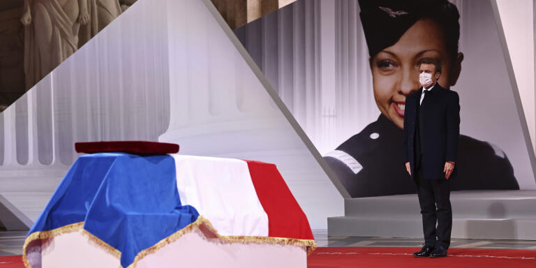 French President Emmanuel Macron pay respect to the cenotaph of Josephine Baker, covered with the French flag, at the Pantheon in Paris, France, Tuesday, Nov. 30, 2021, where she is to symbolically be inducted, becoming the first Black woman to receive France's highest honor. Her body will stay in Monaco at the request of her family. (Sarah Meyssonnier/Pool Photo via AP)