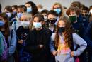 (FILES) In this file photograph taken on September 1, 2020, pupils wearing protective masks stand as they listen to an official at Françoise-Giroud middle school in Vincennes, east of Paris, on the first day of the school year amid the coronavirus (Covid-19) pandemic. The wearing of masks will again be compulsory in elementary schools from November 15, 2021, throughout France, the education ministry announced on November 10, after President Emmanuel Macron's address. "From next Monday, all departments will switch to level 2 of the health protocol", with "all pupils" in elementary schools wearing masks again, the ministry said in a statement sent to AFP. (Photo by Martin BUREAU / AFP)
