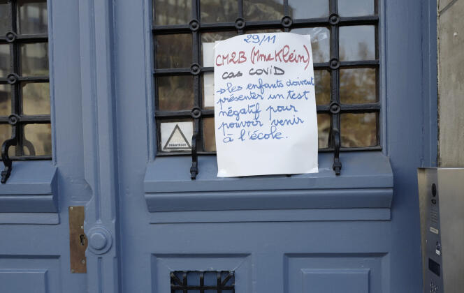 An advertisement relating to Covid-19 displayed on the door of a primary school in Paris on November 29, 2021.