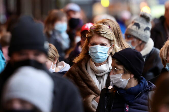 Des passants portent des masques de protection contre le Covid-19, près des Galeries Lafayette, à Paris, le 8 décembre 2021.