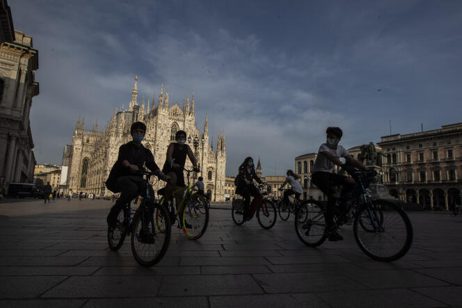 Des cycliste sur la place de la cathédrale de Milan (Italie), en mai 2020.