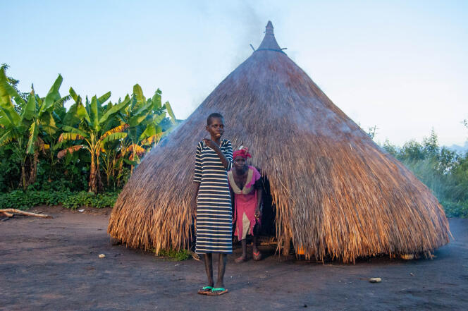 Foybe, 22, with nodding syndrome, and his mother, outside their kitchen in Maridi, South Sudan.
