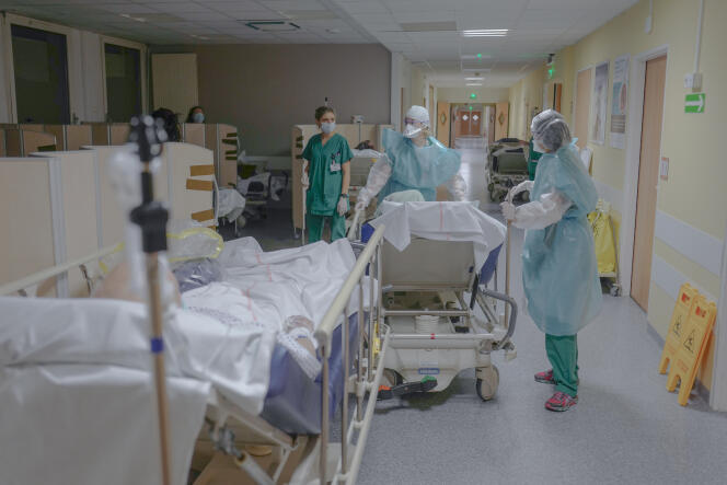 Deux infirmières conduisent un patient infecté par le Covid-19 jusqu’au scanner pour une radio des poumons, au poste de soins du service de réanimation médicale de l’hôpital Louis-Pasteur à Colmar, dans le Haut-Rhin, le 1er décembre 2021.