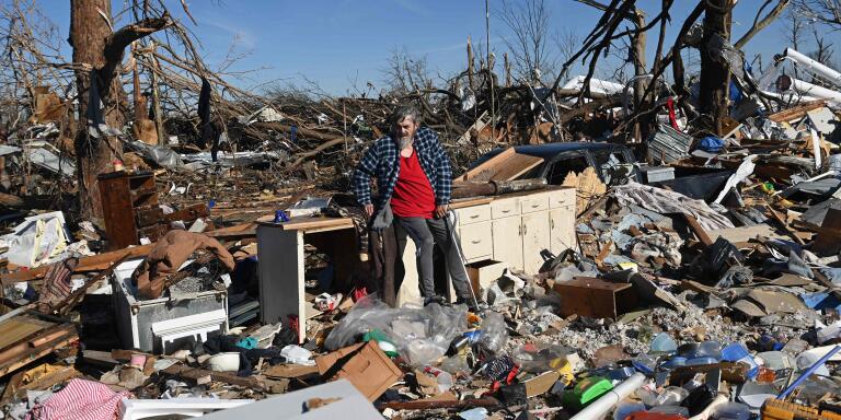 TOPSHOT - Bogdan Gaicki surveys tornado damage after extreme weather hit the region December 12, 2021, in Mayfield, Kentucky. Dozens of devastating tornadoes roared through five US states overnight, leaving more than 80 people dead Saturday in what President Joe Biden said was 