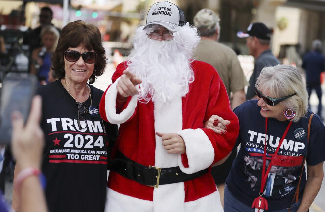 Un père noël, avec une casquette qui se moque de Joe Biden, pose avec une militante de Donald Trump, à Orlando (Floride), le 12 décembre 2021.