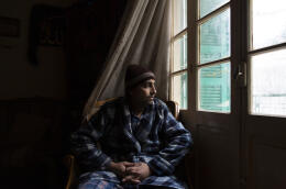 Ali Hamdan sits by the window at his apartment in Choueifat, southeast of Beirut, Lebanon, Thursday, November 25, 2021.