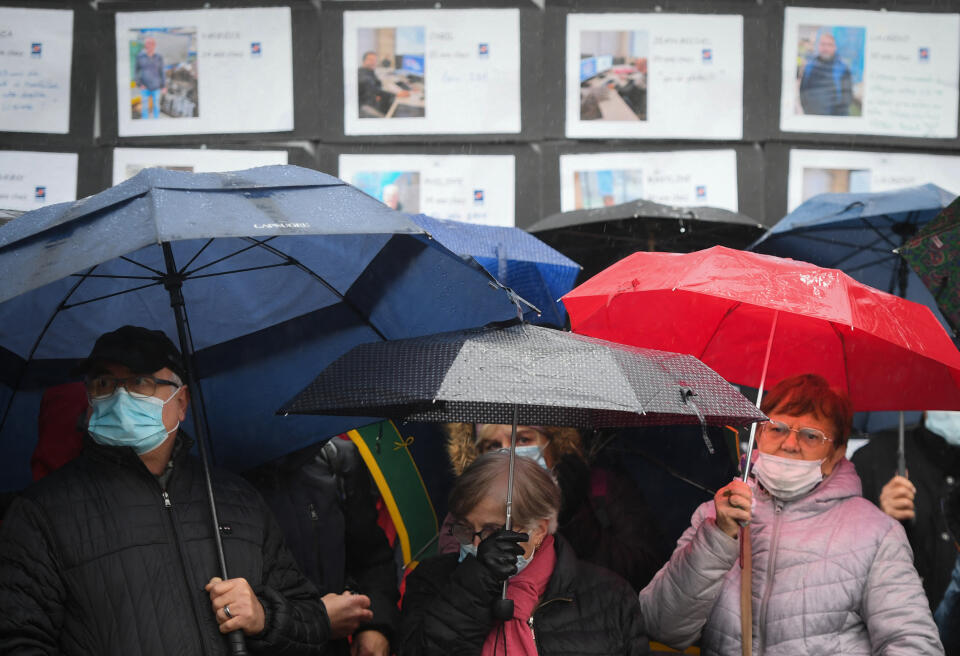 The striking workers and their supporters listen to the speeches of the Trade Unionists, under the rain, in front of testimonies of SAM employees at the Societe Aveyronnaise de Metallurgie (SAM) factory, in Viviez, south-western France, on December 1, 2021. - Several thousand people gathered in front of the Societe Aveyronnaise de Metallurgie (SAM) to give their support to the employees on strike to protest against the latest decisions taken regarding the closure of the Jinjiang SAM, in Viviez, south-western France, on December 1, 2021. (Photo by Valentine CHAPUIS / AFP)