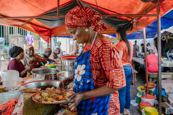 A woman serves a dish of thieboudiene near the Kermel market in Dakar, the Senegalese capital, on December 14, 2021.