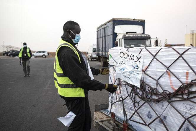 Un ouvrier déballe un carton de vaccins AstraZeneca, envoyé par le programme mondial de vaccination Covax, à Dakar, en mars 2021.