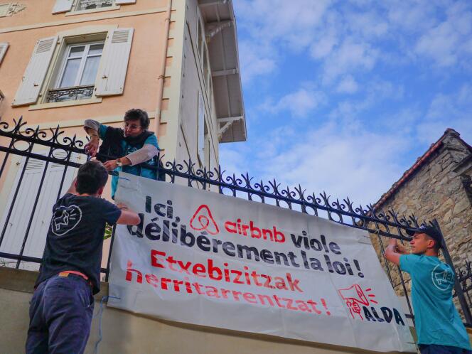 Pour dénoncer la crise du logement, des militants associatifs accrochent une banderole devant un immeuble d’Airbnb, à Biarritz, le 21  septembre.