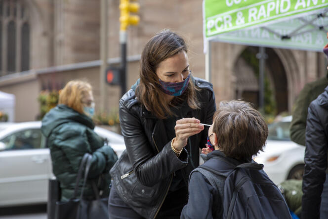 A woman, Katie Lucey, administers a Covid-19 test to her son, Maguire, in New York City on December 16, 2021.