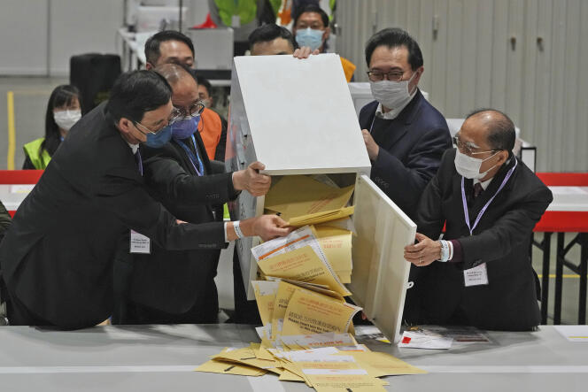 Barnabas Fung, second from right, and other officials from the Hong Kong Election Affairs Commission empty a ballot box to count votes, during parliamentary elections on Sunday, December 19, 2021.