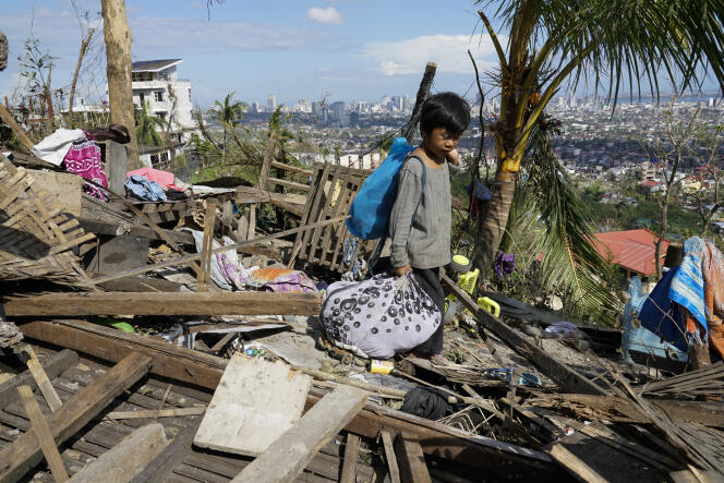 A child collects some personal belongings from the ruins of his home in Cebu province (central Philippines) on December 19, 2021.