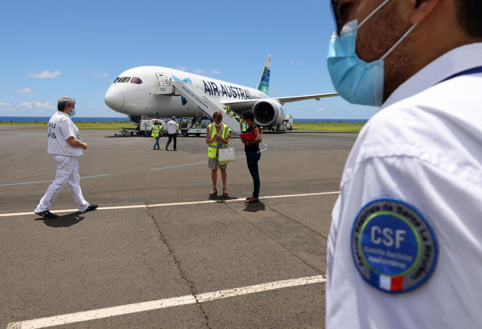 A SAMU (French Urgent Medical Aid Service) member walks toward an Air Austral company's medicalized plane at Roland Garros airport in Sainte-Marie on the French Indian Ocean island of La Reunion on March 4, 2021 before evacuating four Covid-19 patients to Paris. (Photo by Richard BOUHET / AFP)