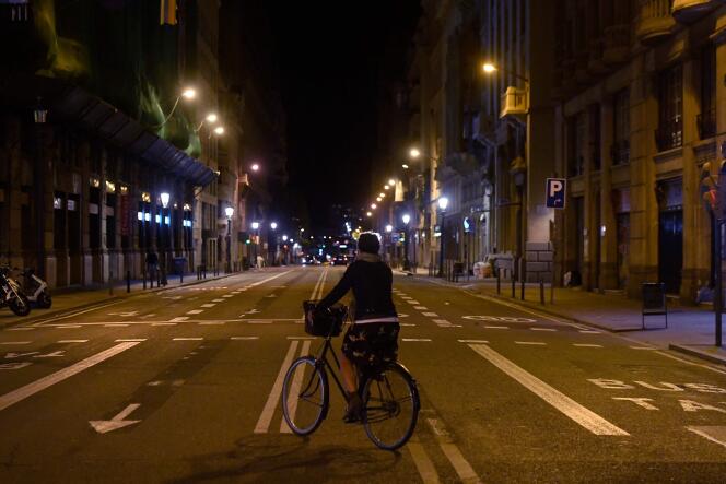 A woman rides a bicycle during a previous curfew on October 26, 2020 in Barcelona.