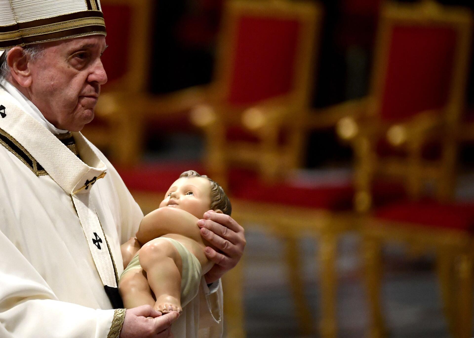 Le pape François tient une figurine de l’enfant Jésus, vendredi 24 décembre 2021, lors de la messe du réveillon, à Saint-Pierre de Rome.