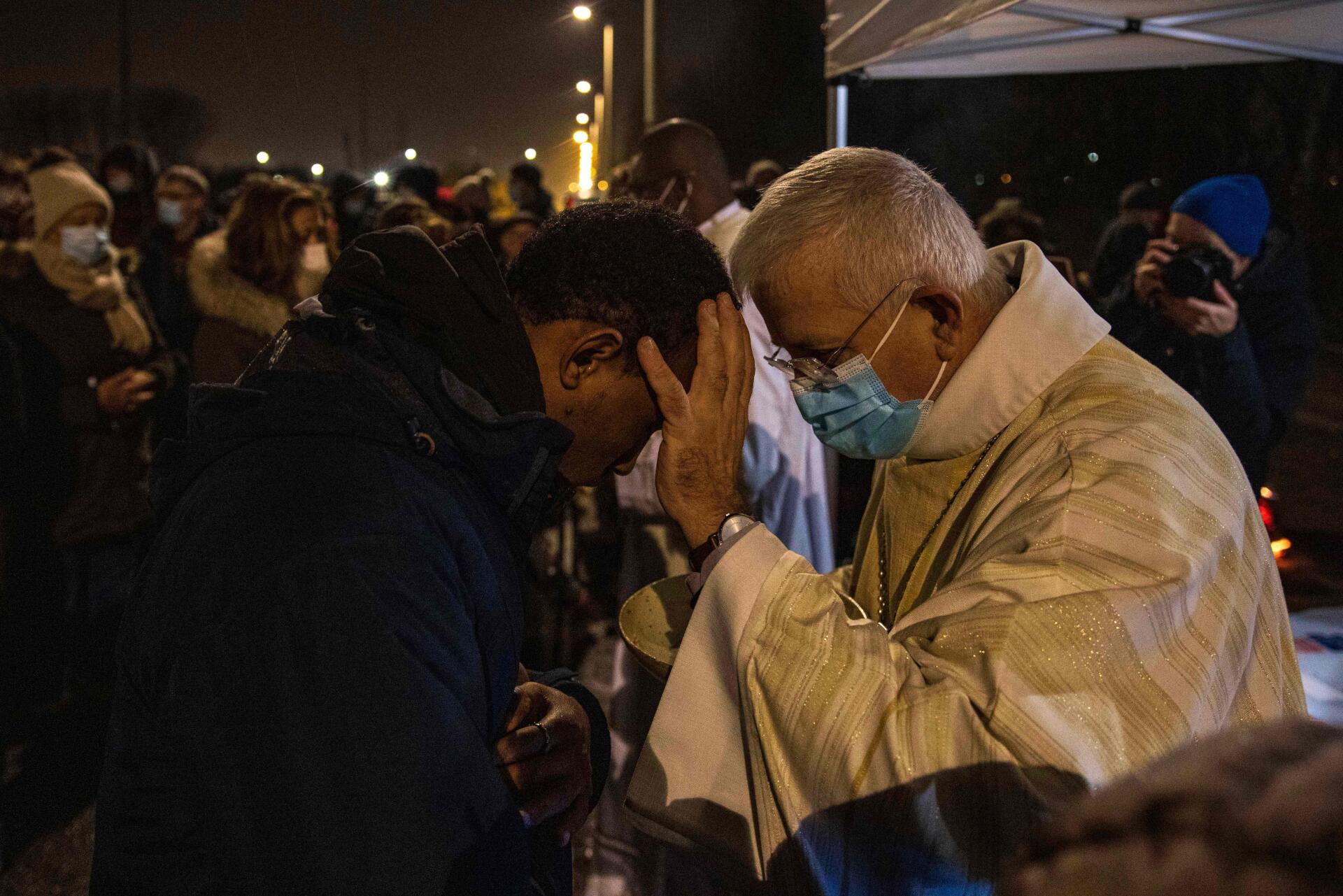 De bisschop van Arras, monseigneur Olivier Leborgne, zegent de gelovigen op vrijdag 24 december tijdens de mis die wordt georganiseerd in een migrantenkamp in Calais (Pas de Calais).