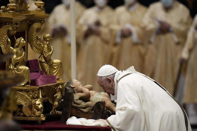 O Papa beija a estátua do menino Jesus no Vaticano em 24 de dezembro de 2021.