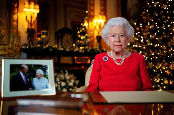 Elizabeth II enregistre son message de Noël dans le salon blanc du château de Windsor, à côté d’une photo de la reine et du duc d’Edimbourg, à Windsor, en Grande-Bretagne, le 23 décembre 2021.
