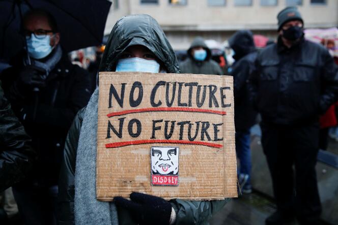 A woman holds a “No culture, no future” banner during the demonstration in Brussels on December 26, 2021.