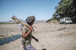 A member of the Amhara militia walks out of a river near the village of Wanza, Ethiopia, on December 09, 2021.