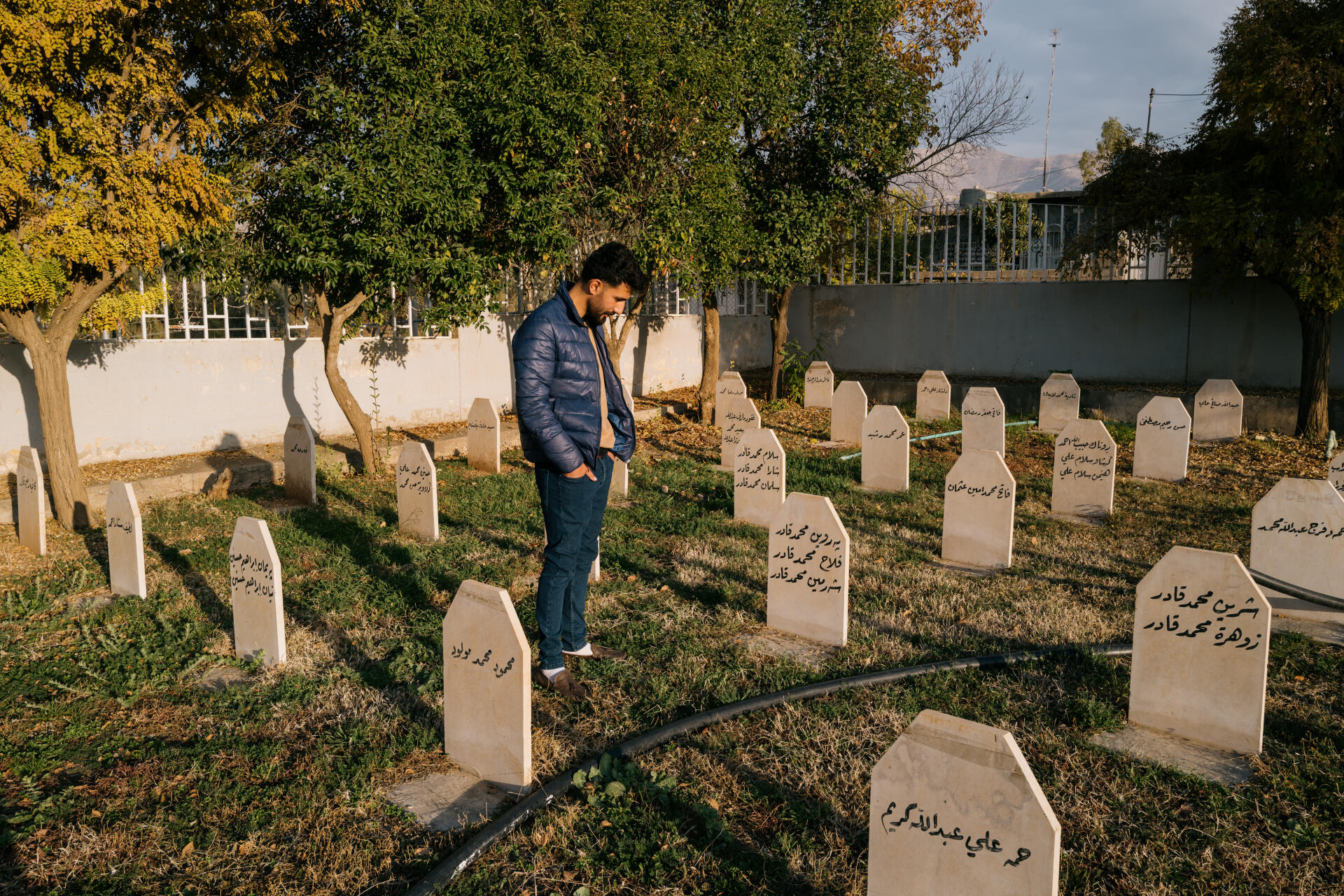 Muhammed Fatah Muhammed devant la tombe de membres de sa famille dans le cimetière du massacre de Halabja, en Irak, le 15 décembre 2021. Il rêve de tenter sa chance en Europe.