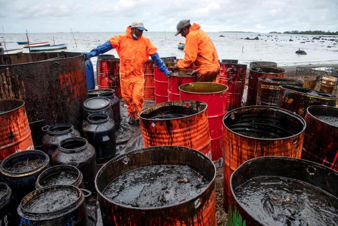 I lavoratori raccolgono l'olio combustibile che è stato lavato su una spiaggia a Rivière de Creole, Mauritius, il 15 agosto 2020.