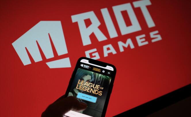 Le jeu « League of Legends » sur un écran de smartphone, devant le logo du studio Riot Games, à Los Angeles, le 27 décembre 2021.