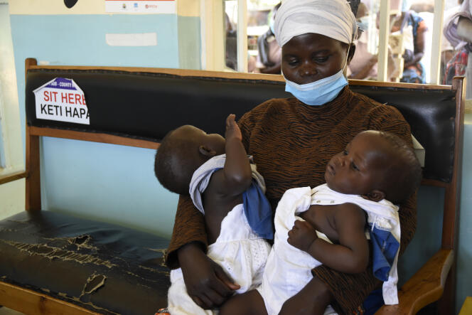 Maureen Atieno attend sur un banc de la clinique de Yala, dans l’ouest du Kenya, que ses jumeaux de 9 mois se fassent vacciner, le 16 décembre 2021.