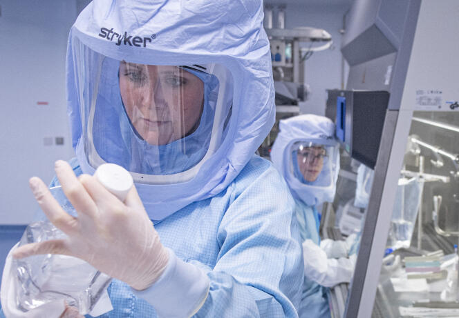 Vêtus de combinaisons de protection intégrale, des assistants de laboratoire de la société Biontech simulent les dernières étapes de la production du vaccin Corona sur un bioréacteur dans une salle blanche du nouveau site de production de Marbourg, en Allemagne, le 30 mars 2021.