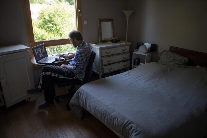 Un homme participe à une vidéoconférence alors qu’il travaille depuis son domicile, le 14 mai 2020 à Vertou, en périphérie de Nantes.