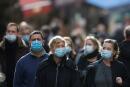 Le persone, indossando maschere protettive, camminano per Mouffetard street, in mezzo alla diffusione della pandemia del coronavirus (COVID-19), a Parigi, Francia, 30 dicembre 2021. REUTERS/Christian Hartmann