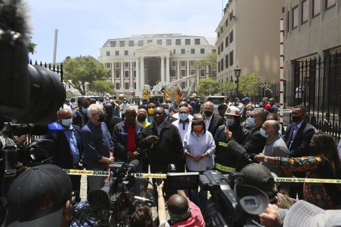 Le président sud-africain Cyril Ramaphosa s’adresse à la presse devant le Parlement en partie détruit par le feu, au Cap, le 2 janvier 2022.