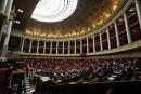 Parliament members attend a session of questions to the Government at the French National Assembly in Paris, France, Tuesday, Jan. 4, 2022. France's lower house of parliament is voting on a government plan to require full vaccination to enter restaurants, tourist sites, sports facilities and other venues. (AP Photo/Francois Mori)