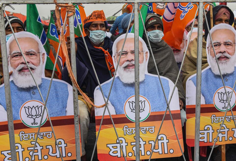 Bharatiya Janata Party (BJP) supporters hold BJP party flags and cut-outs with portrait of BJP leader and India's Prime Minister Narendra Modi during a rally ahead of the state assembly elections in Ferozepur on January 5, 2022 which was reportedly cancelled later citing security concerns. (Photo by NARINDER NANU / AFP)