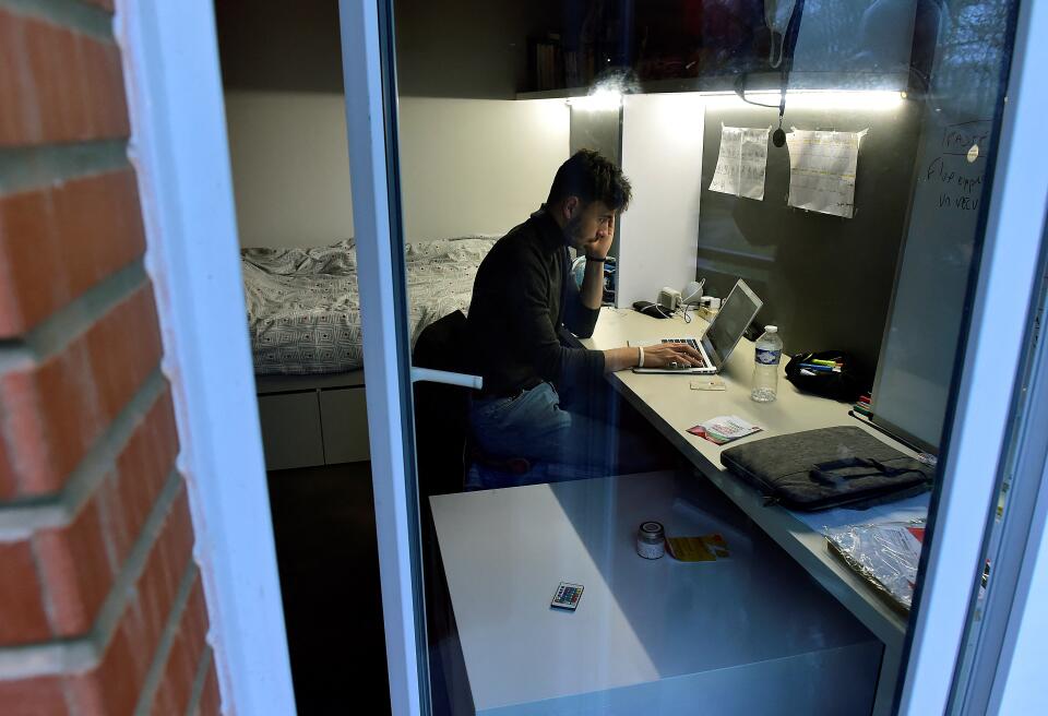 Naya, 24, a Masters 2 university level physical education student, works in his student room at a university residence in Toulouse, southern France, on February 1, 2021, amid the Covid-19 (novel coronavirus) pandemic. - Due to restrictions over the Covid-19 pandemic in France, French university students are carrying out their curriculum mainly in a distance learning format. With gathering restrictions, empty campuses and a lack in student job opportunities, some students are increasingly isolated and are facing distress. (Photo by GEORGES GOBET / AFP)