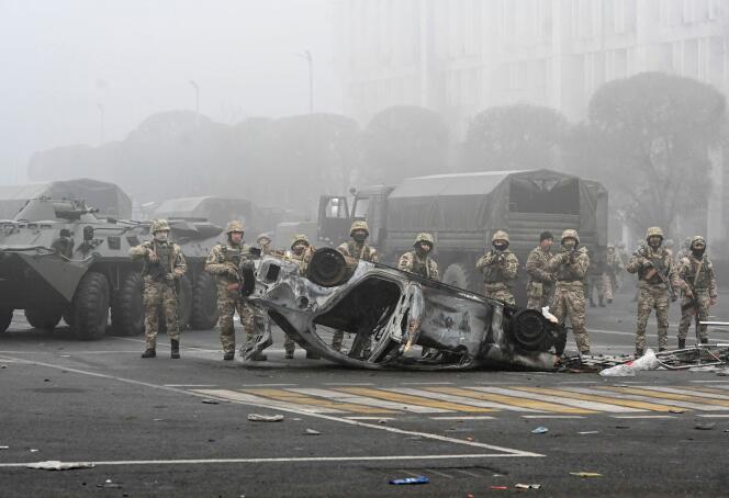 Des soldats à proximité d’une automobile incendiée dans le centre d’Almaty, le 6 janvier 2022.