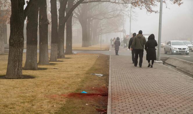In central Almaty, passers-by walk along traces of blood on January 6, 2022.