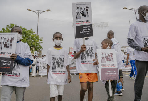 Children demonstrate with signs during the white march against violence committed towards women in Dakar on December 19, 2021. (Photo by CARMEN ABD ALI / AFP)